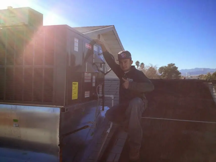 HVAC technician performing HVAC Inspection on a rooftop unit in Brewster
